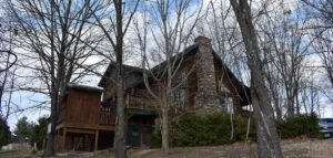 Exterior view of a rustic lodge resort building nestled among trees at Bear Creek Cabin Resort in Walnut Shade, Missouri