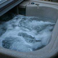 Outdoor hot tub on a cabin deck at Creekside Cabin in Bear Creek Cabin Resort near Branson MO